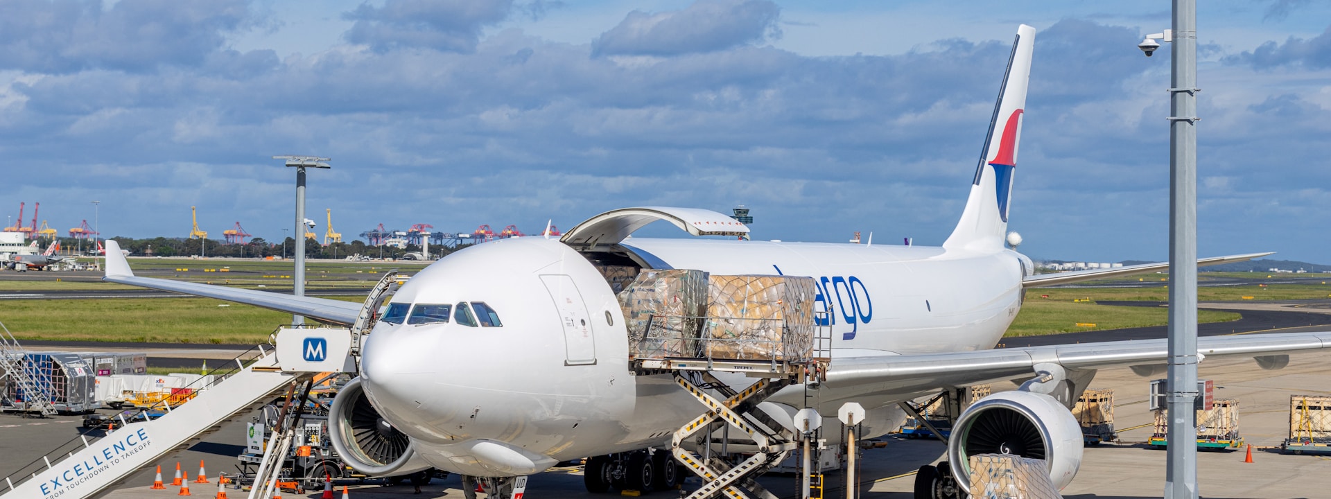 Cargo aircraft being unloaded at airport tarmac — air freight logistics